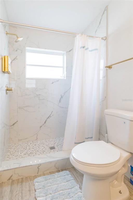 1613 Druid Road Clearwater, FL 33756 - Photo 26 of 47 a white toilet sitting next to a bath tub shower