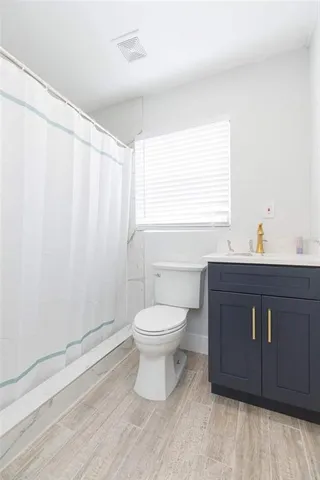 a bathroom with a toilet a sink and a window