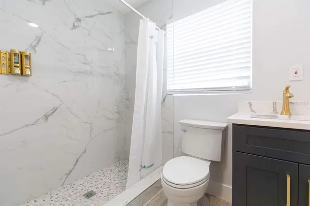 a bathroom with a sink a toilet and shower