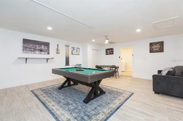 a room with furniture pool table and paintings on the wall