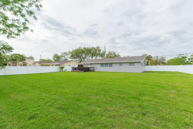 a view of a house with a big yard and large trees