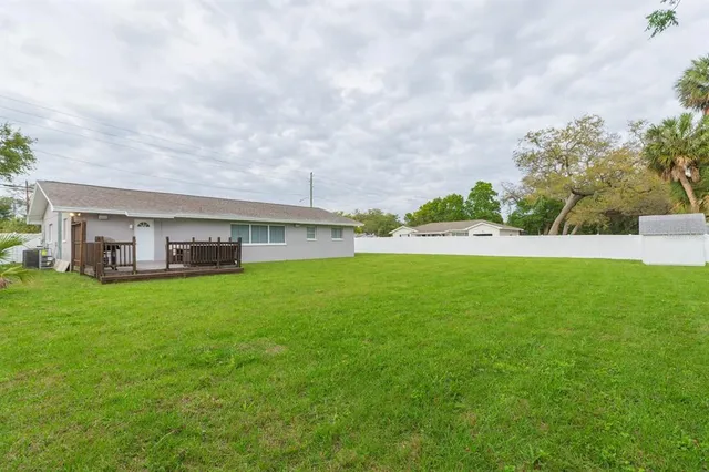 a view of a house with a big yard and large trees