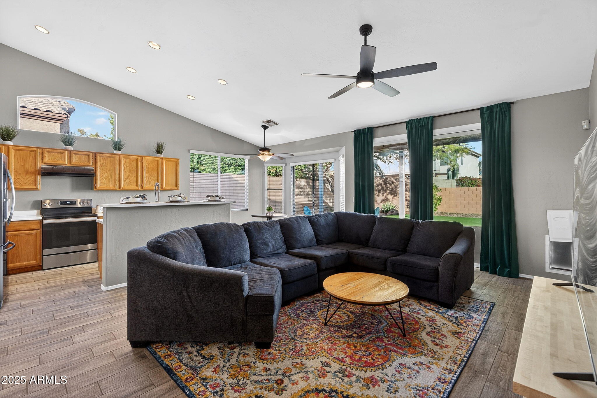 a living room with furniture kitchen view and a chandelier