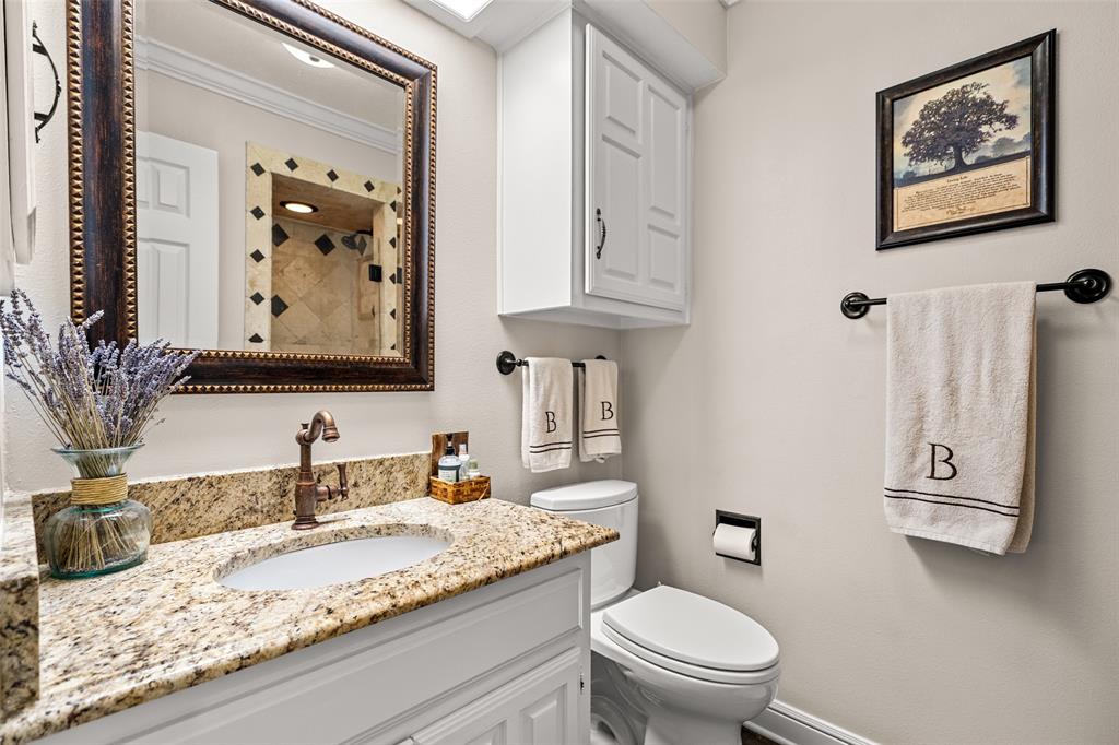 400 Hunters Ridge Circle Coppell, TX 75019 - Photo 21 of 35 a bathroom with a granite countertop toilet a sink and a mirror