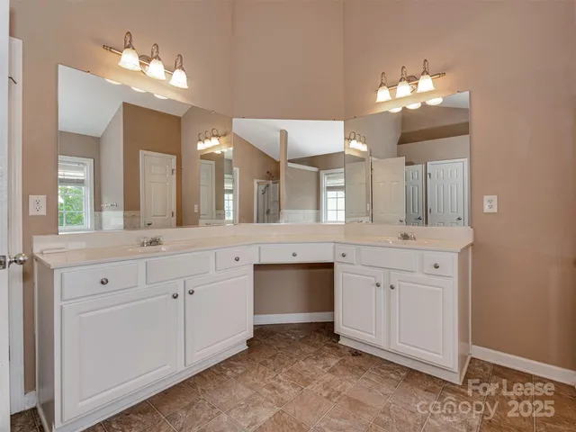 a spacious bathroom with a double vanity sink and a mirror