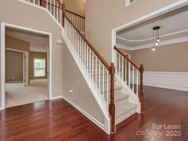 a view of staircase with lots of frames and a rug