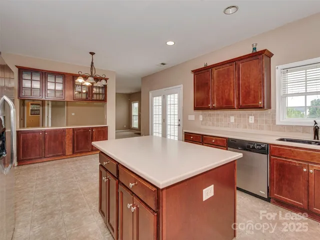 a kitchen that has a sink a microwave oven a stove and white cabinets