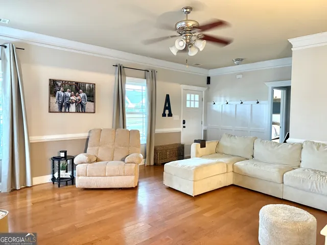 a living room with furniture and a wooden floor