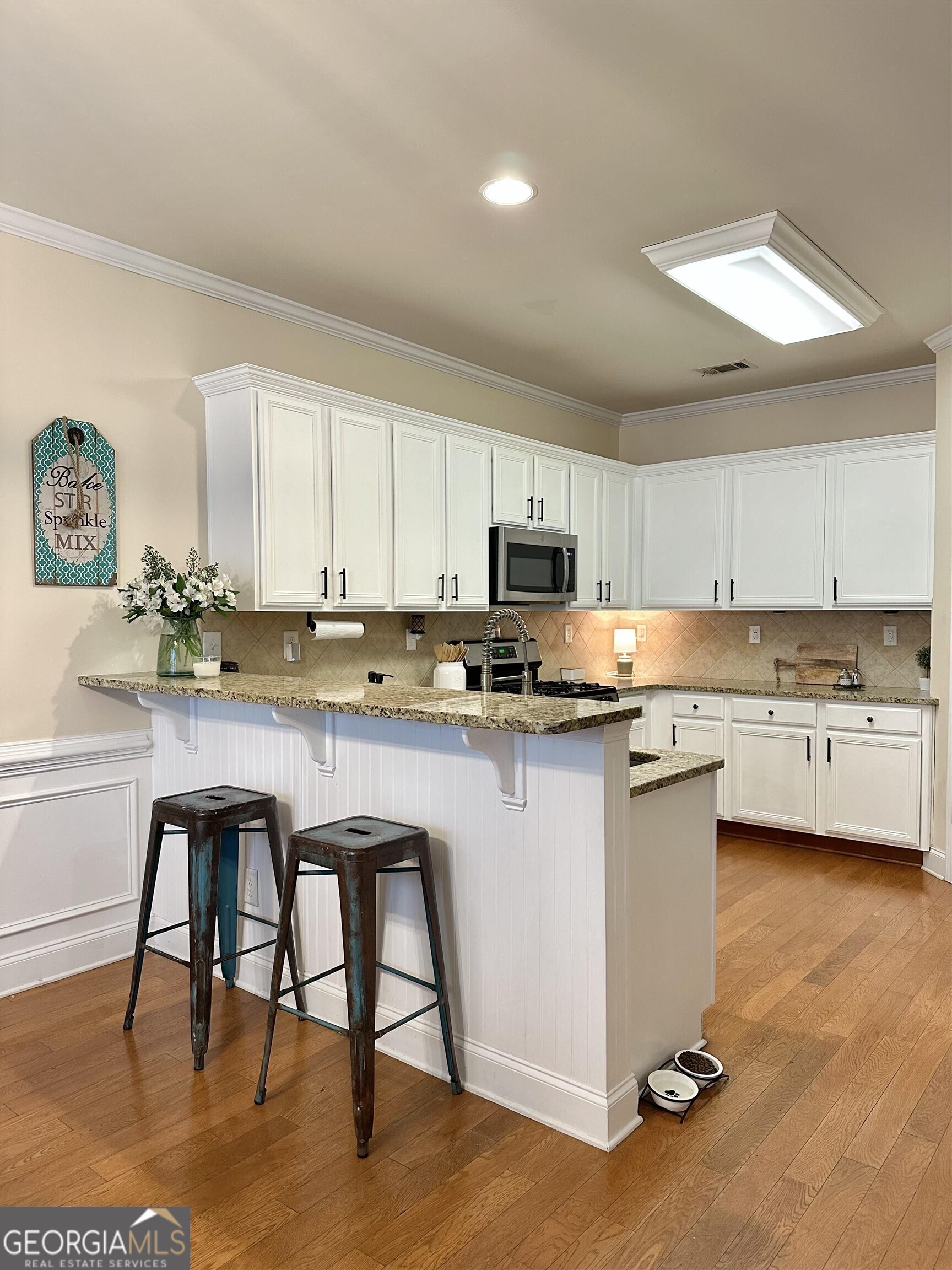 226 Rogue Road Social Circle, GA 30025 - Photo 9 of 23 a kitchen with stainless steel appliances granite countertop a stove a sink dishwasher and a refrigerator with wooden floor