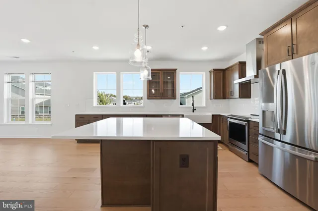 a kitchen with stainless steel appliances granite countertop a sink a stove and a refrigerator