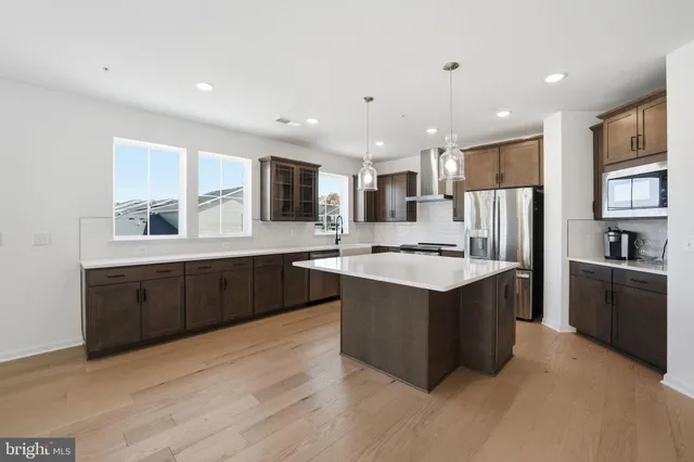 a large kitchen with stainless steel appliances granite countertop a sink a stove a refrigerator and cabinets