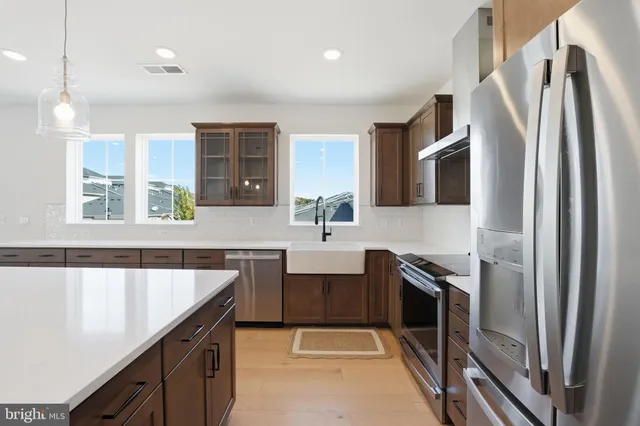 a kitchen with stainless steel appliances a sink stove and refrigerator