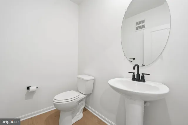 a bathroom with a toilet a sink and mirror