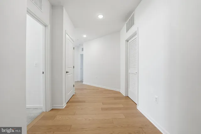 a view of a hallway with wooden floor