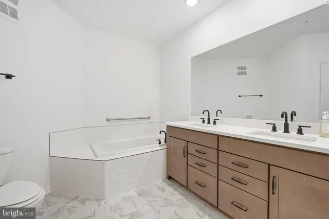 a bathroom with a granite countertop sink mirror and toilet
