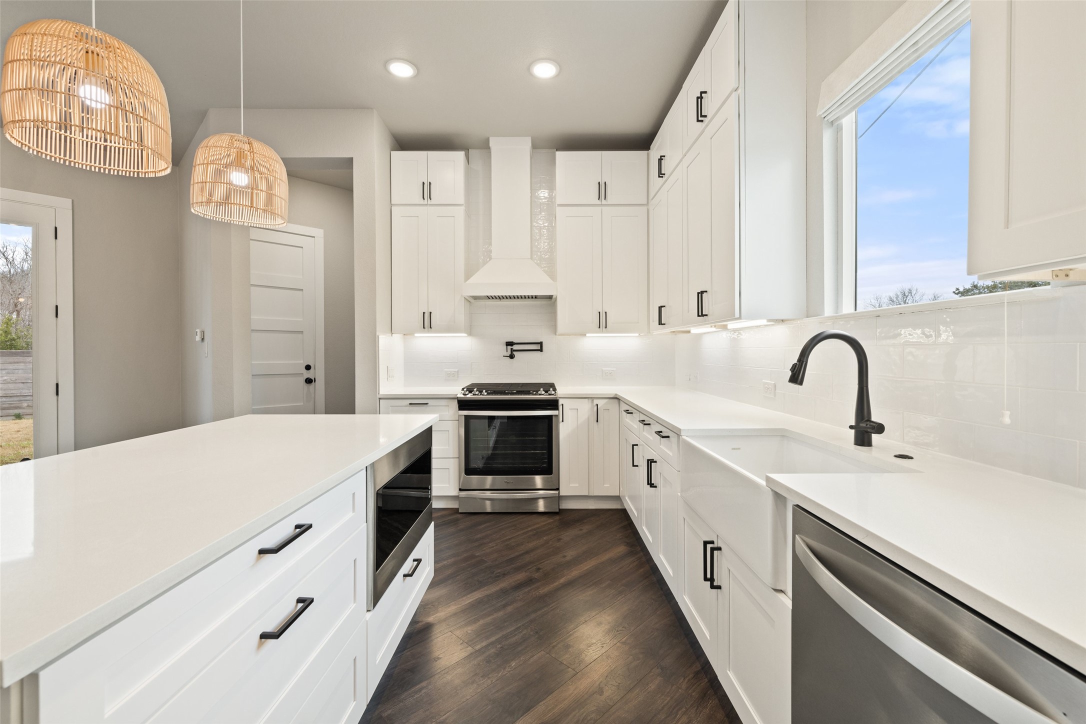a large white kitchen with stainless steel appliances sink and cabinets