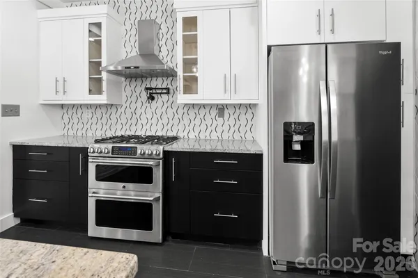 a kitchen with stainless steel appliances granite countertop a refrigerator and a stove