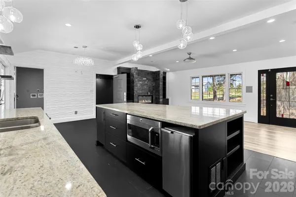 a large kitchen with stainless steel appliances granite countertop a large kitchen island and a sink