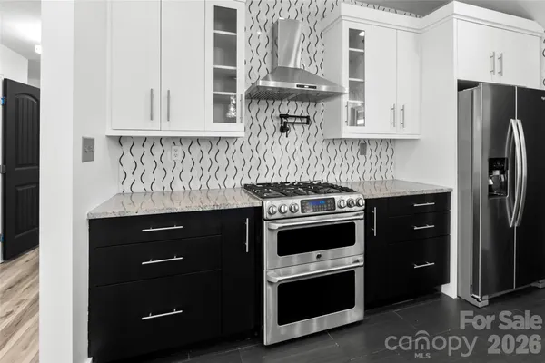 a kitchen with stainless steel appliances granite countertop a refrigerator and a stove