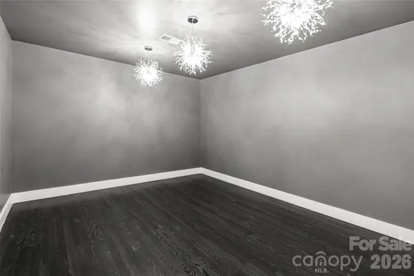 a view of wooden floor and chandelier in closet