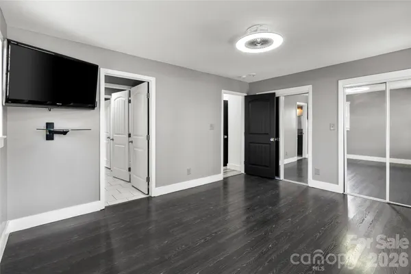 an empty room with wooden floor and mirror