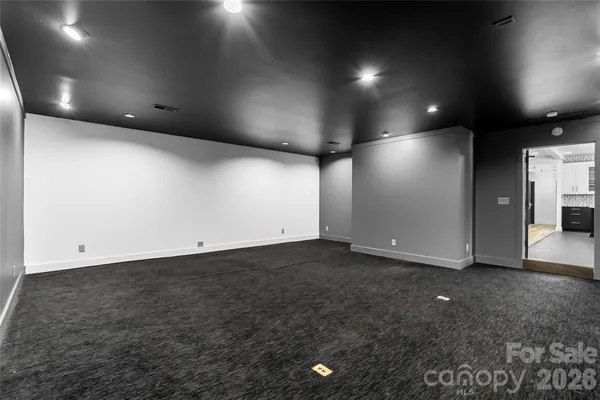 an empty room with stainless steel appliances wooden floor and view living room