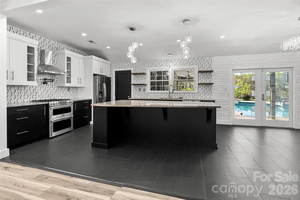 a large kitchen with kitchen island a sink stainless steel appliances and cabinets