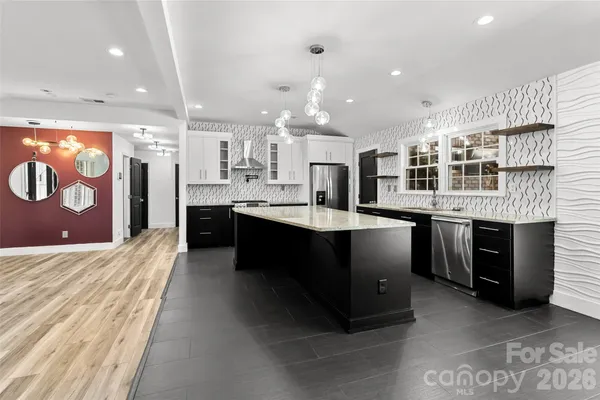 a open kitchen with stainless steel appliances granite countertop a sink a stove and a refrigerator