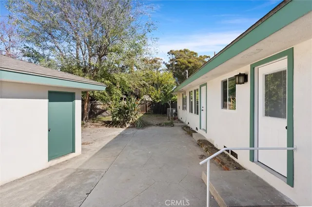 a view of a house with backyard and trees