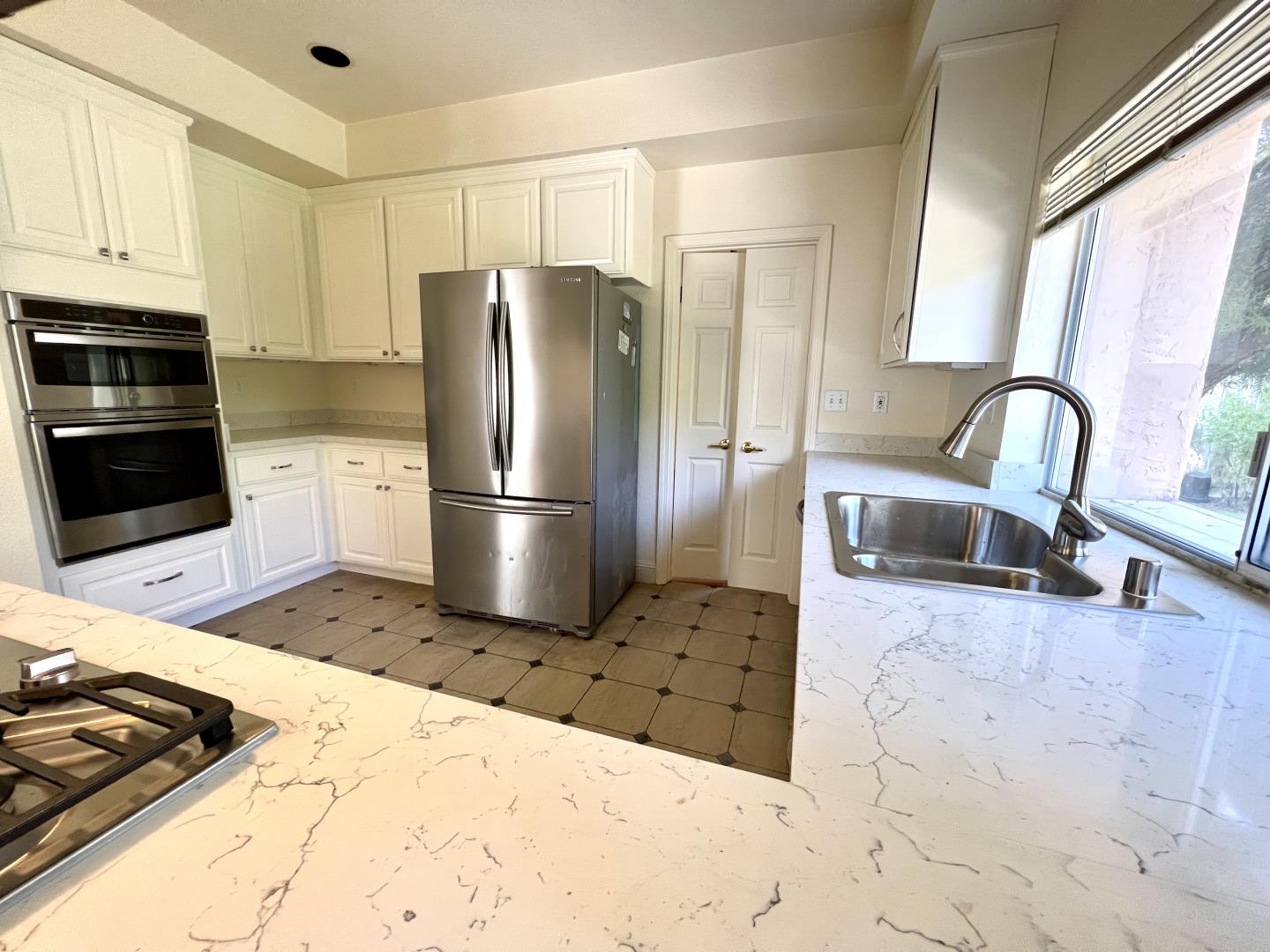 11792 Pine Brook Lane Cupertino, CA 95014 - Photo 5 of 19 a kitchen with granite countertop a refrigerator and a sink