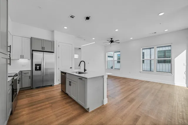a kitchen with stainless steel appliances granite countertop a sink and wooden floor