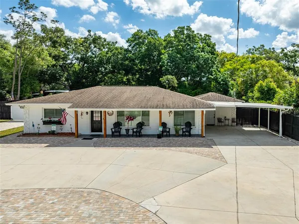 a front view of a house with a yard and trees