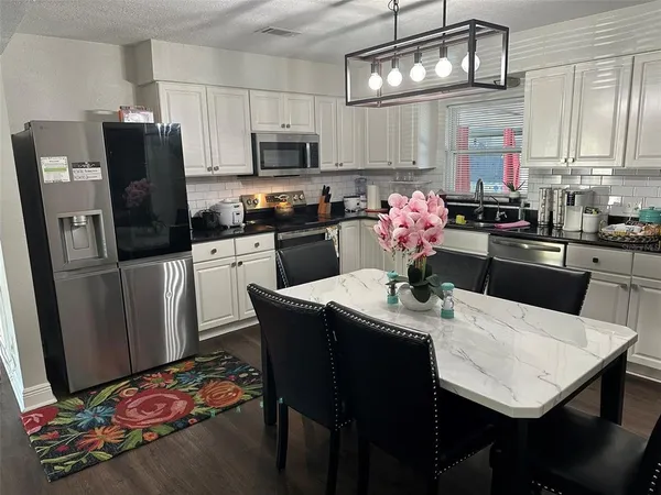 a view of a dining room with furniture a chandelier and wooden floor