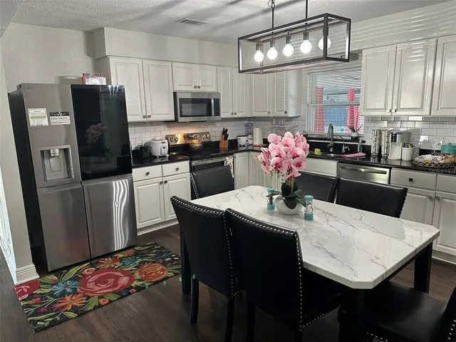 a view of a dining room with furniture a chandelier and wooden floor