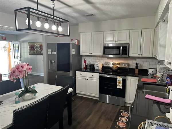 a room with water heater and wooden cabinets