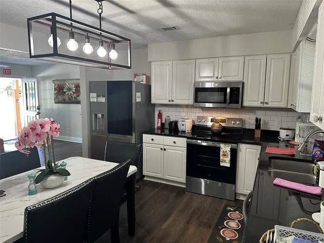 a room with water heater and wooden cabinets