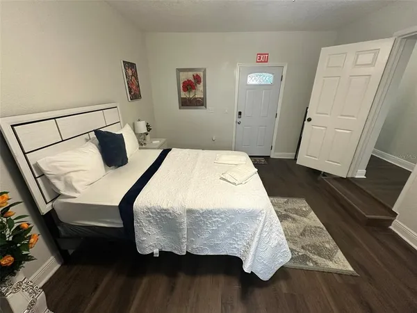 a bedroom with a bed and a flat tv screen on dresser
