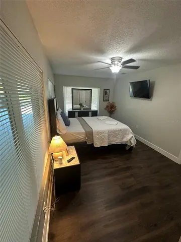 a view of a backyard with table and chairs and potted plants and large trees