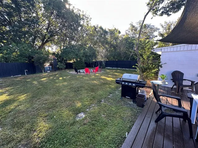 a view of a house with backyard and tree