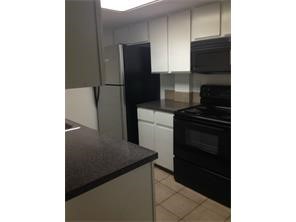 2401 Leon Street, Unit 305 Austin, TX 78705 - Photo 5 of 13 a kitchen with a refrigerator and a stove