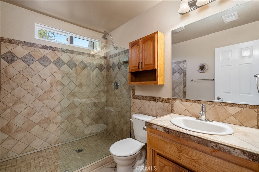 9340 Mountain View Drive Atascadero, CA 93422 - Photo 18 of 50 a bathroom with a granite countertop sink a toilet and a mirror
