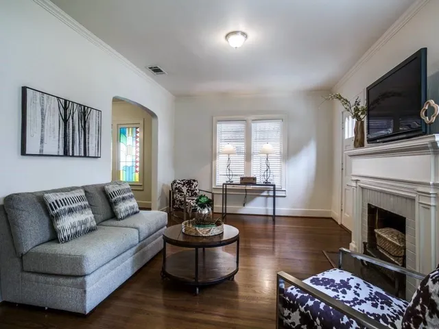 a living room with furniture a fireplace and a flat screen tv