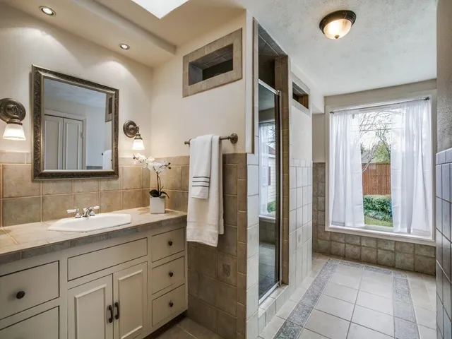 a spacious bathroom with a double vanity sink and a mirror