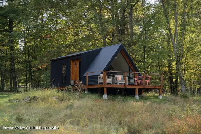 a wooden house with trees in the background