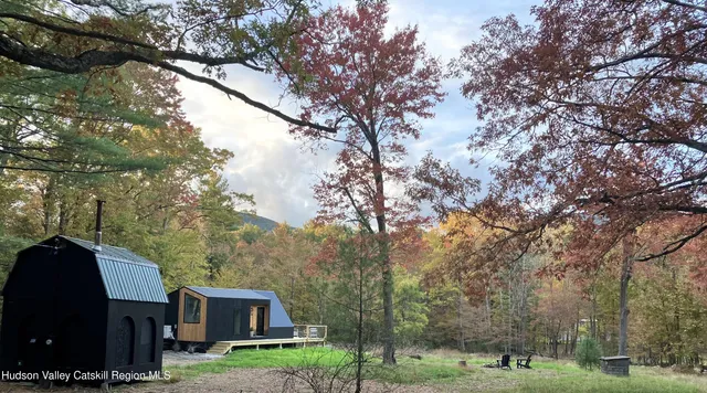 a view of a yard in front of a house with large tree
