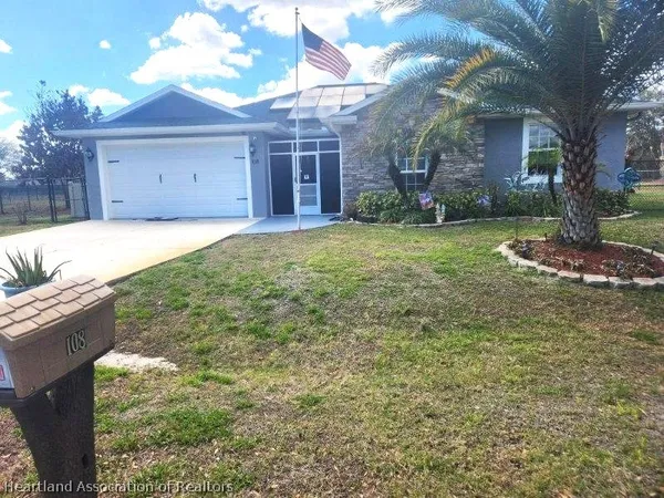 a view of a house with backyard and a tree