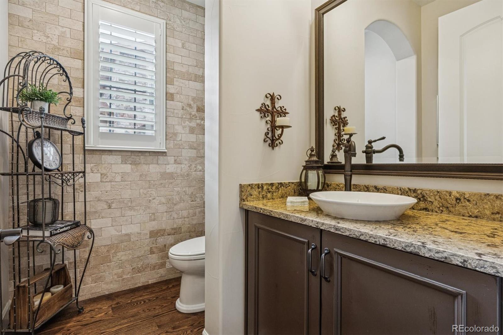 2065 Primo Road, Unit F Highlands Ranch, CO 80129 - Photo 17 of 37 a bathroom with a granite countertop sink a toilet and a mirror