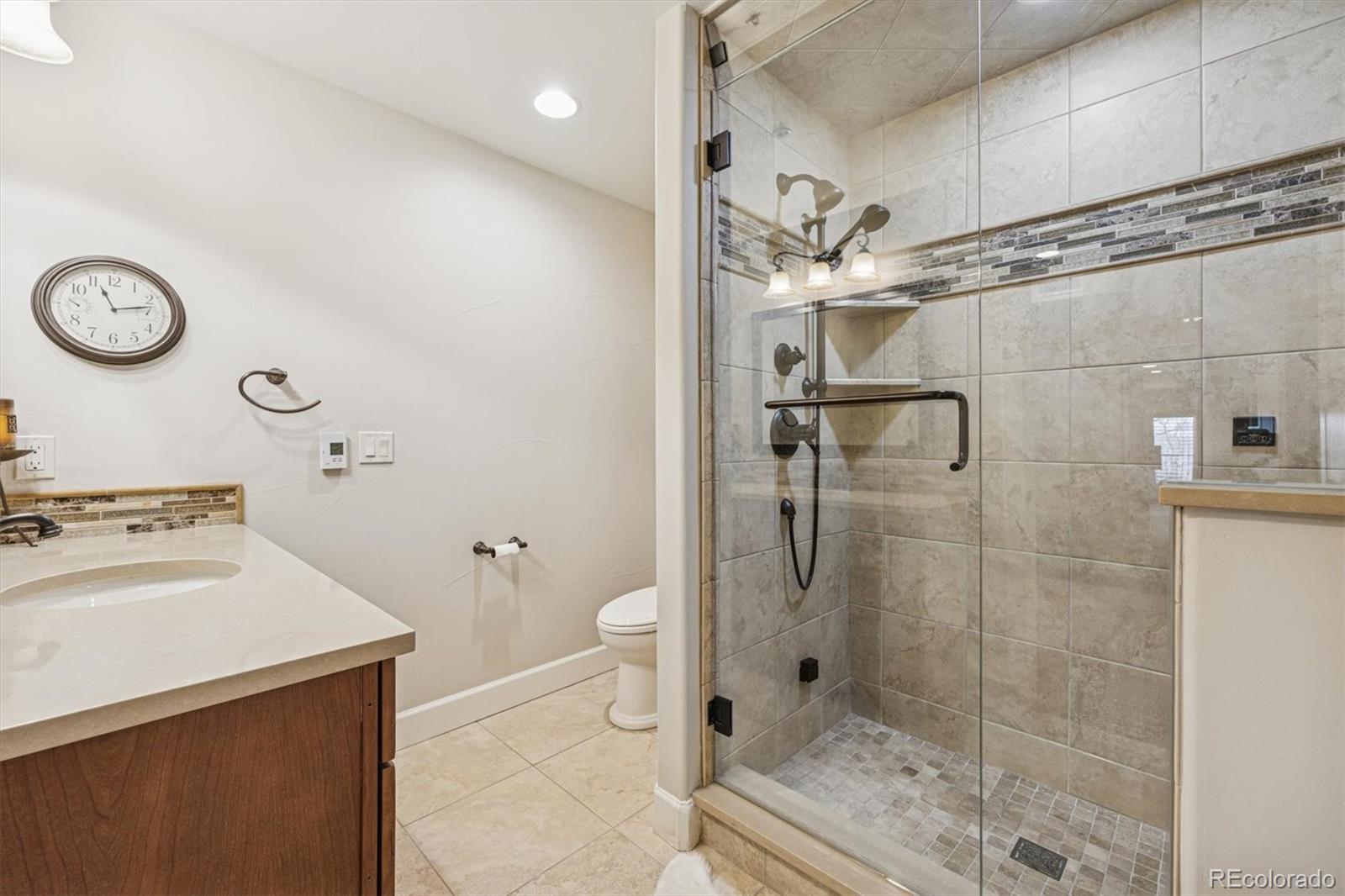 2065 Primo Road, Unit F Highlands Ranch, CO 80129 - Photo 32 of 37 a bathroom with a shower a toilet and a sink