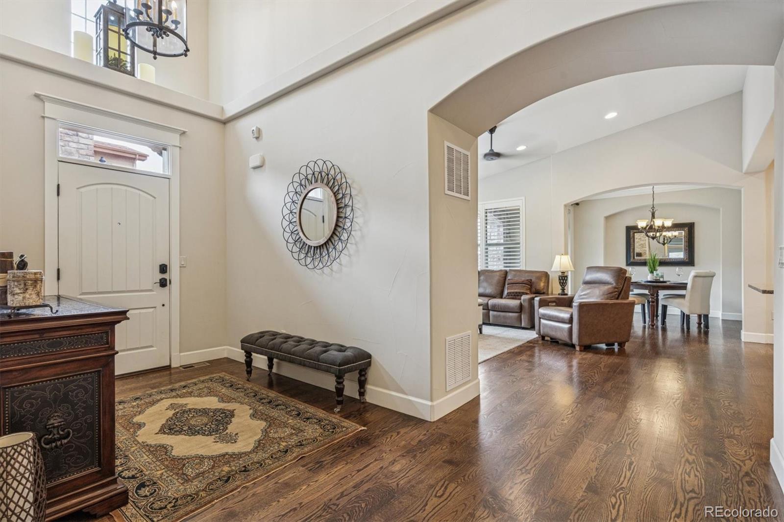 2065 Primo Road, Unit F Highlands Ranch, CO 80129 - Photo 7 of 37 a living room with furniture a wooden floor and a chandelier