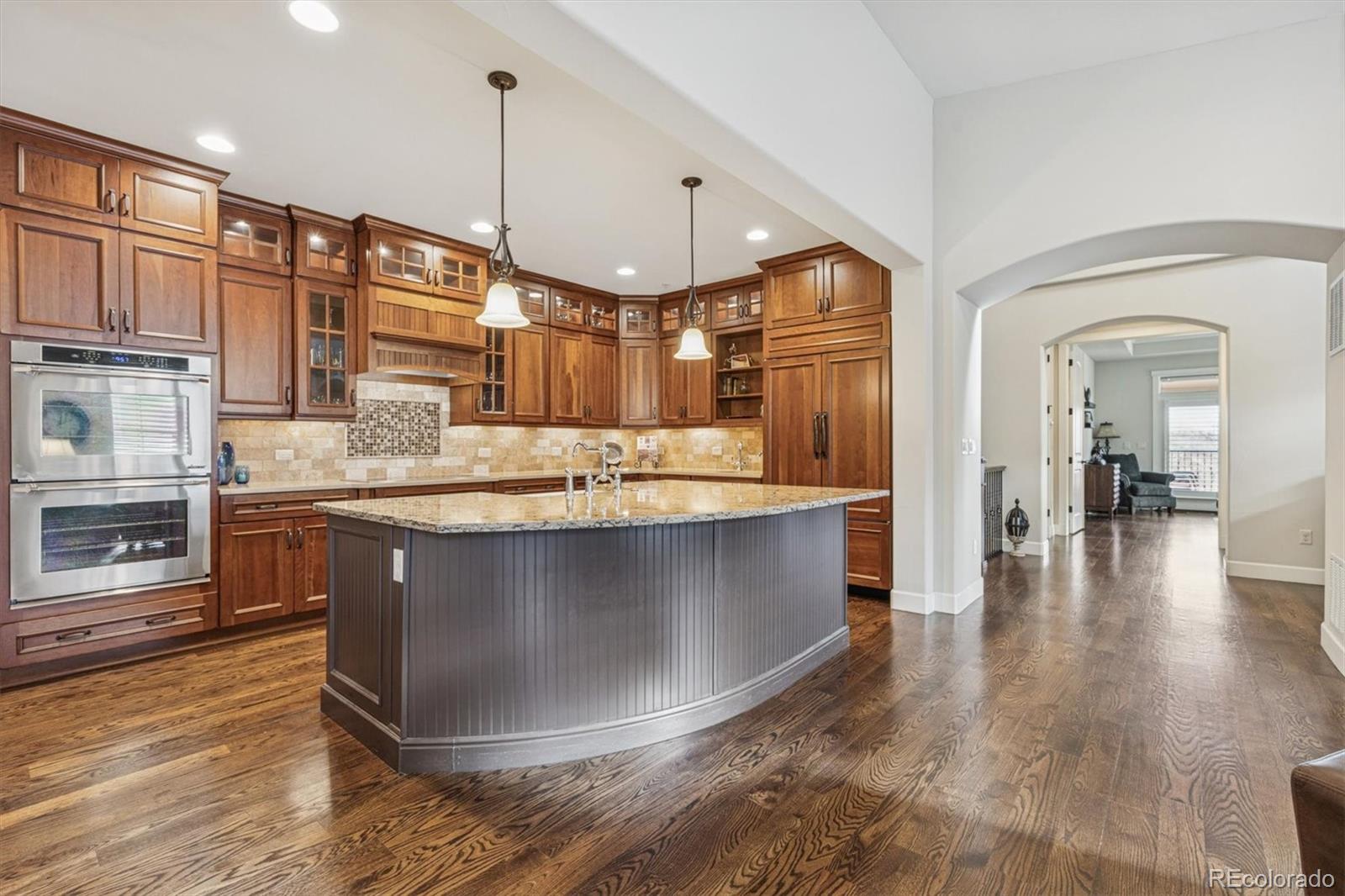 2065 Primo Road, Unit F Highlands Ranch, CO 80129 - Photo 10 of 37 a kitchen with kitchen island granite countertop a stove and a wooden floors